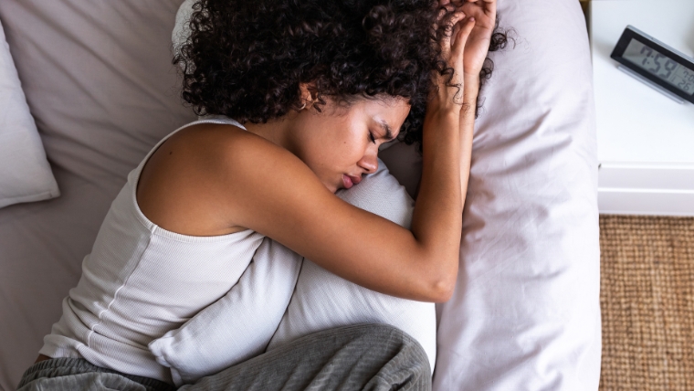 Beyond Depression 5 Common Illnesses Associated with Higher Risk in Patients with Depression Black woman lying in bed uncomfortable and upset hugging her pillow | Beyond Depression 5 Common Illnesses Associated with Higher Risk in Patients with Depression | Mindful Health Solutions