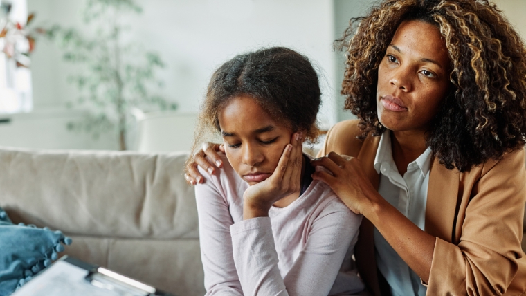 Supportive mom and sad daughter in a therapist's office | Therapy for Kids: 5 Signs that Your Child Should See a Therapist | Mindful Health Solutions