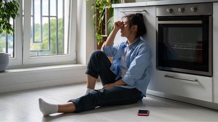 Feminine looking person sitting on floor looking defeated | 8 Effective Ways to Deal with Narcissistic Personalities | Mindful Health Solutions