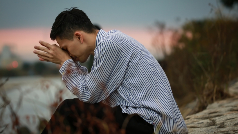 Unraveling-the-Five-Major-Risk-Factors-for-Clinical-Depression Man with head in hands on beach | Unraveling the Five Major Risk Factors for Clinical Depression
