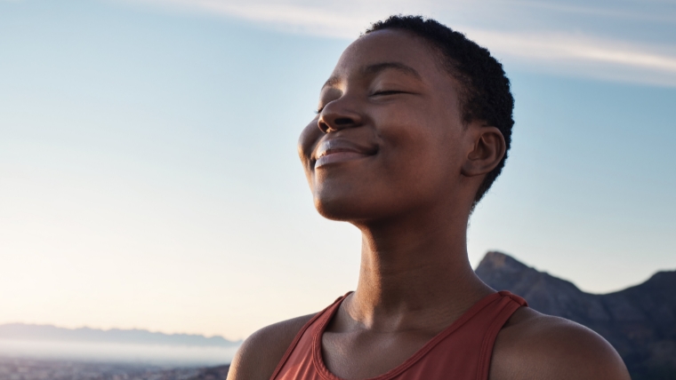 Black woman outside breathing with a smile on her face | How TMS Literally Changes Your Mind Medication-Free Depression Treatment | Mindful Health Solutions