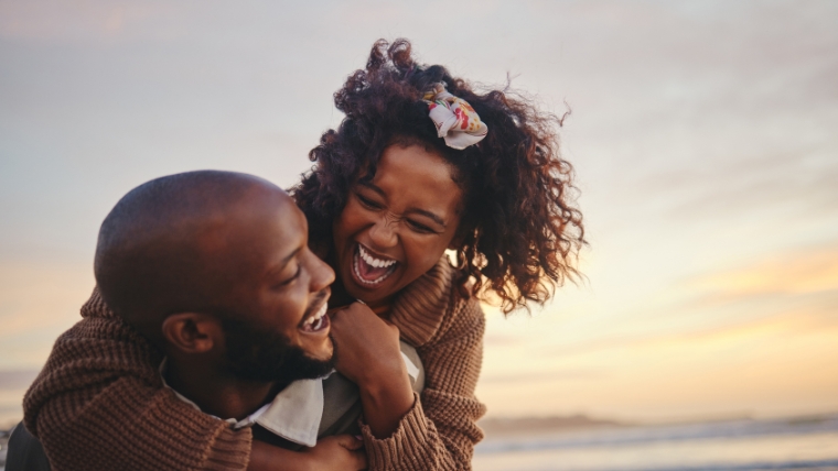 Couple laughing on the beach | 5 Boundaries To Set in Your Relationship that Benefit Everyone's Mental Health | Mindful Heatlh Solutions