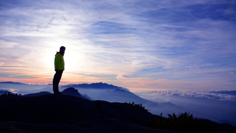 Ketamine-for-Mental-Health-A-Miracle-Drug-or-Hype Man standing on top of a mountain, overlooking a landscape of mountaintops and clouds | Ketamine for Mental Health A Miracle Drug or Hype | Mindful Health Solutions