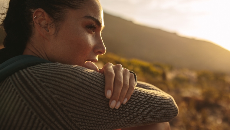 Emotional-Triggers-Why-They-Matter-How-to-Manage-Them-Effectively Close-up of a woman sitting outside in the sun thinking and reflecting seriously | Emotional Triggers Why They Matter & How to Manage Them Effectively | Mindful Health Solutions