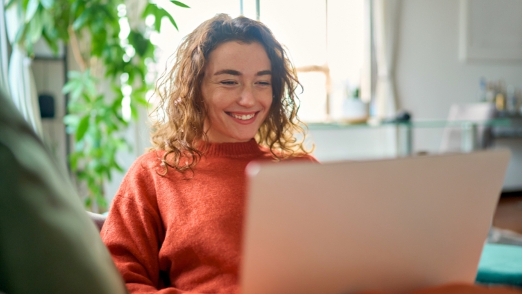 Managing Depression as a Freelancer 10 Ways to Boost Mental Well-Being Relaxed happy young woman sitting on sofa using laptop | Managing Depression as a Freelancer: 10 Ways to Boost Mental Well-Being | Mindful Health Solutions
